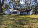 The backyard of this single Gathering house features lush grass and is surrounded by mature trees at 37654 Eiland Blvd, Zephyrhills, FL 33542