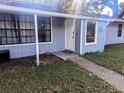 Close up of the front entrance with a neatly maintained walkway and classic white door and trim at 37654 Eiland Blvd, Zephyrhills, FL 33542