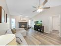 Inviting living room with a cozy fireplace, vaulted ceiling, and stylish wood-look floors at 3908 N Forbes Rd, Plant City, FL 33565