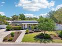 Charming single-story home with a brick driveway, a manicured lawn, and solar panels on the roof at 4091 Cherry Ne St, St Petersburg, FL 33703