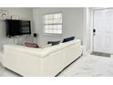 Living area features a white sectional, tile floors, and plenty of natural light at 5118 Tennis Court Circle, Tampa, FL 33617