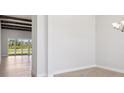 Living area with wooden beams, light wood floors and sliding glass doors at 5152 Wildwind Dr, Apollo Beach, FL 33572