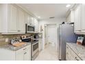 Modern kitchen with stainless steel appliances, granite countertops, and ample cabinet space at 5335 Sand Crane Ct, Wesley Chapel, FL 33543