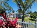Beautiful home with manicured lawn, white picket fence, and vibrant red plants enhancing curb appeal at 6401 30Th N Way, St Petersburg, FL 33702