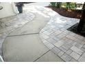 A beautiful walkway is landscaped with brick pavers and concrete sections. A tree stands beside it at 6410 Beaver Way, Tampa, FL 33625