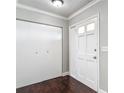 Bright foyer featuring a closet with white doors, dark wood floors, and a paneled interior door at 7280 Tarrytown Dr, Spring Hill, FL 34606