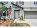 Close up of the front door of the home with an American flag, and trimmed landscaping at 754 8Th Nw St, Ruskin, FL 33570