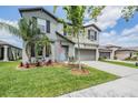Gray two-story home with neat landscaping, two-car garage, and an American flag by the door at 754 8Th Nw St, Ruskin, FL 33570