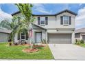 Gray two-story home with neat landscaping and lawn, driveway, and two-car garage at 754 8Th Nw St, Ruskin, FL 33570