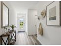 Bright hallway with wood floors, decorative accents, and a clear view to the front door at 1004 Spotted Egret Loop, Ruskin, FL 33570