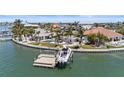 Beautiful waterfront home boasts a private boat dock, sparkling pool, and lush landscaping at 11050 7Th E St, Treasure Island, FL 33706