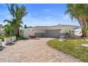 Charming single-story home with a well-manicured lawn and a brick-paved driveway at 11050 7Th E St, Treasure Island, FL 33706