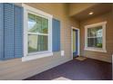 Inviting front porch with blue shutters, a blue door and textured carpeting at 13611 Circa Crossing Dr, Lithia, FL 33547