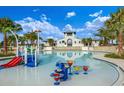 Community pool featuring splash pad, water features, lounge area, and palm trees at 13611 Circa Crossing Dr, Lithia, FL 33547