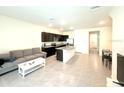 Bright open-concept living room and kitchen space with tile flooring and modern finishes at 1490 Colt Creek Pl, Wesley Chapel, FL 33543