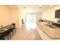 Open concept living and dining area showcasing tile floors, a kitchen island, and sliding glass doors at 1490 Colt Creek Pl, Wesley Chapel, FL 33543