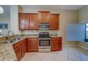 Well-lit kitchen featuring stainless steel appliances, granite countertops, and ample cabinet space at 15430 Long Cypress Dr, Ruskin, FL 33573