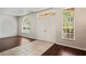 Bright foyer featuring tile and hardwood flooring with natural light from multiple windows at 16119 Bridgedale Dr, Lithia, FL 33547