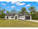 Well-maintained single-story home with neat landscaping and a two-car garage in a lush setting at 16431 Penn State Rd, Weeki Wachee, FL 34614
