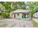 Inviting single-story home with a carport, newly painted exterior, and bright red door at 1720 W Arch St, Tampa, FL 33607
