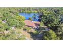 Aerial view of a charming home featuring a well-manicured lawn and lake views at 201 Gornto Lake Rd, Brandon, FL 33510