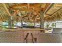 Outdoor tiki bar features a cozy space for entertaining in a tropical setting, complete with seating and a thatched roof at 208 44Th Ne Ave, St Petersburg, FL 33703