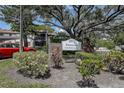 Attractive Estancia Condominiums entrance sign with landscaping, a red car is parked in the background at 2971 Estancia Blvd # 328, Clearwater, FL 33761