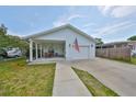 Inviting single-story home featuring a covered porch, a garage, manicured lawn, and an American flag at 3042 57Th N Ave, St Petersburg, FL 33714