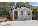 Charming home featuring a light gray exterior, a small wooden porch, and a well-maintained yard at 3230 Queensboro S Ave, St Petersburg, FL 33712