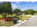 Landscaped front yard featuring mature trees, green grass, and a sidewalk leading to the house at 3351 San Jose St, Clearwater, FL 33759