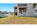 Backyard featuring a covered patio, stairs to an upper-level balcony, and waterfront canal access at 4396 5Th Isle Dr, Hernando Beach, FL 34607
