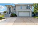 Two-story home featuring a two-car garage, covered entry, and concrete driveway and entry stairs at 4396 5Th Isle Dr, Hernando Beach, FL 34607