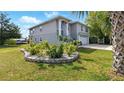 Two-story home featuring a two-car garage, manicured landscaping, and healthy lawn at 4396 5Th Isle Dr, Hernando Beach, FL 34607