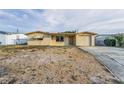 Charming single-story home featuring a light-colored exterior, attached garage, and gravel front yard at 4920 Zodiac Ave, Holiday, FL 34690