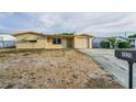 Charming single-story home featuring a light-colored exterior, attached garage, and gravel front yard at 4920 Zodiac Ave, Holiday, FL 34690