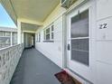 View of the outside hallway leading to the unit's entrance with a storm door at 7050 Sunset Way # 22, St Pete Beach, FL 33706