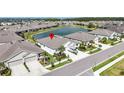 A high-angle view of a home in a lakeside community with lush landscaping and ample parking at 7405 Stonebrook Cir, Wesley Chapel, FL 33545