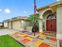 Beautiful home entrance with colorful tiled landing, arched entrance, and an American flag waving above at 10213 Lockwood Pines Ln, Tampa, FL 33635
