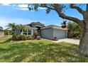 Inviting single-story home with a manicured lawn, mature landscaping, and a two-car garage, offering curb appeal and charm at 1040 Summer Breeze Dr, Brandon, FL 33511
