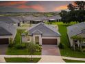 Beautiful aerial view of a home with lush green lawn and mature trees in a quiet neighborhood at 10446 Tupper Cay Dr, San Antonio, FL 33576