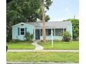 Charming light blue home with green lawn, walkway and mature landscaping at 1069 21St N Ave, St Petersburg, FL 33704