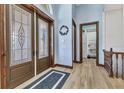 Inviting foyer featuring wood-look floors, decorative double doors, and modern trim at 107 Sunset Dr, Nokomis, FL 34275