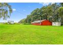 Spacious, red barn on a lush green field provides ample storage and rustic charm at 11015 S County Road 39, Lithia, FL 33547