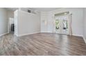 Spacious living area features wood-look floors and natural light flowing in from the French doors at 1119 Hounds Run, Safety Harbor, FL 34695