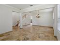 Bright living room showcasing the travertine flooring and staircase at 12817 Darby Ridge Dr, Tampa, FL 33624