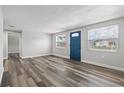 Bright living room with modern flooring, neutral walls, and a blue front door at 1427 Gerard Ln, Holiday, FL 34690