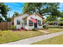 Attractive single-story home with a mature tree, a well-manicured lawn, and an American flag on display at 1601 54Th S St, Gulfport, FL 33707