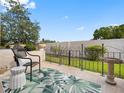 Outdoor seating area with lush garden views and wrought iron accents on the back patio at 1702 Cordova Green, Seminole, FL 33777