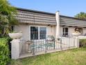 A cozy back patio features an iron gate, potted plants, and outdoor seating at 1702 Cordova Green, Seminole, FL 33777