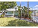 Inviting home with manicured lawn, tropical plants, and a quaint covered front porch at 2014 E Broad St, Tampa, FL 33610